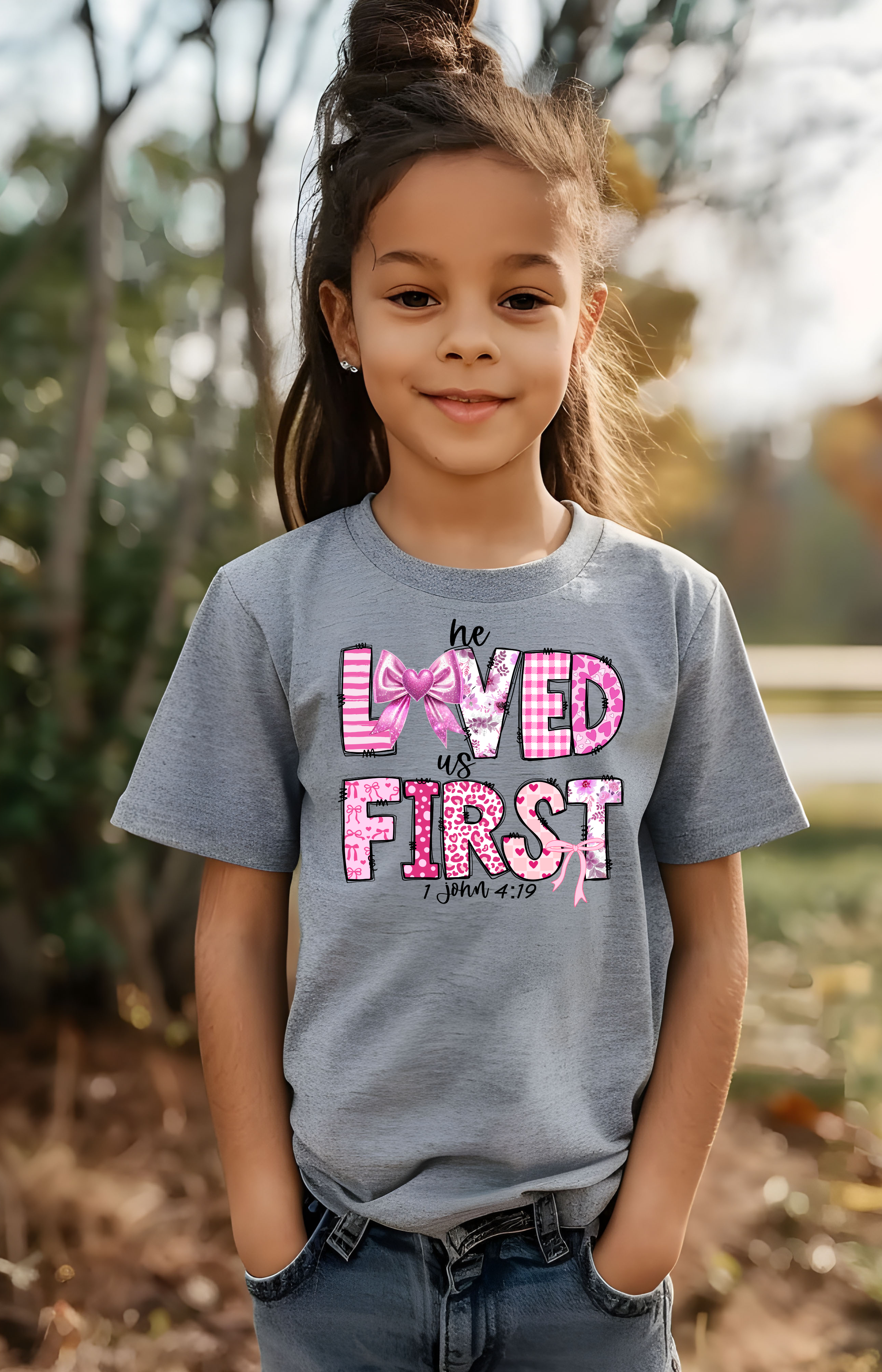 He Loved Us First Kids’ Tee – 1 John 4:19 Faith Shirt