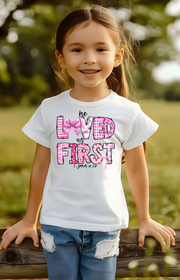 He Loved Us First Kids’ Tee – 1 John 4:19 Faith Shirt