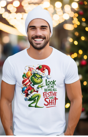 Model wearing a white Christmas T-shirt with a Grinch graphic and festive slogan